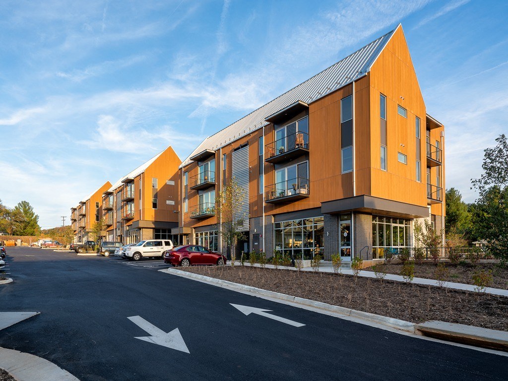 a row of apartment buildings on the side of a street