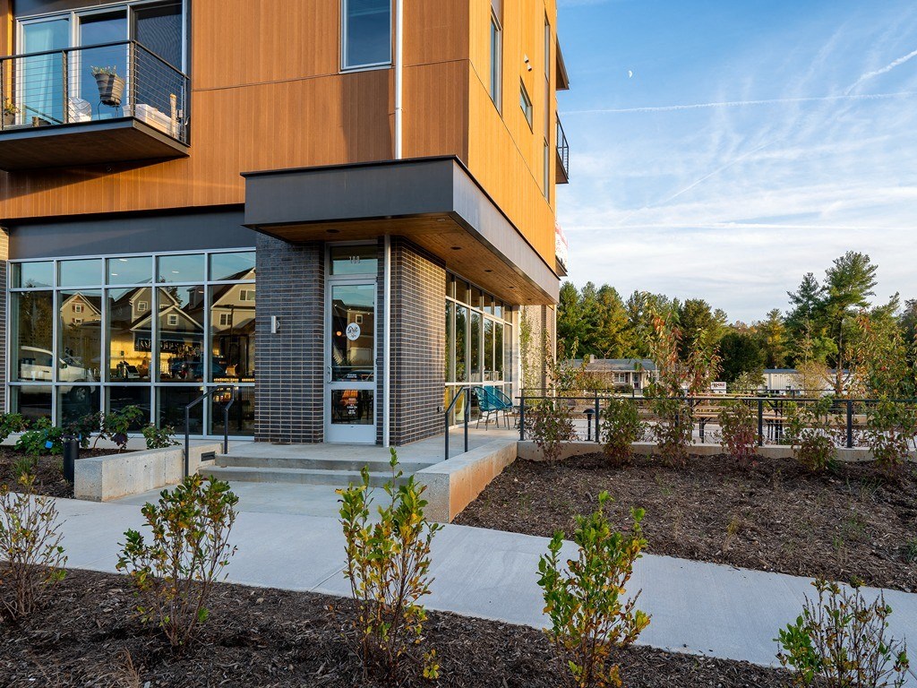 the facade of a building with a patio and a garden