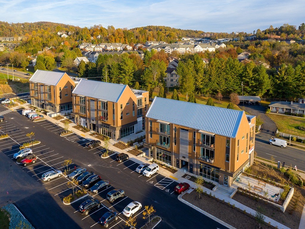 an aerial view of apartment buildings in a parking lot