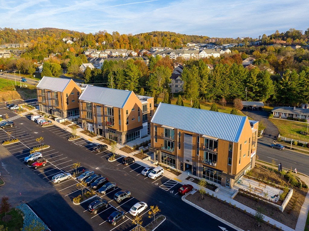 an aerial view of three buildings and a parking lot