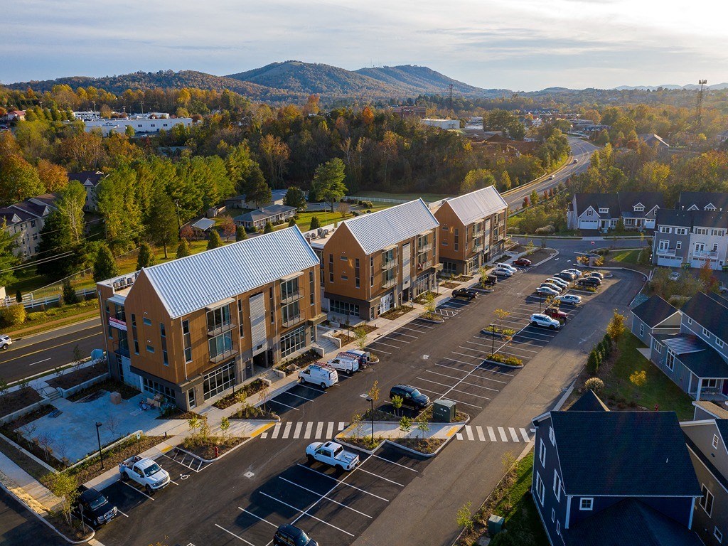 an aerial view of a building with cars parked in a parking lot