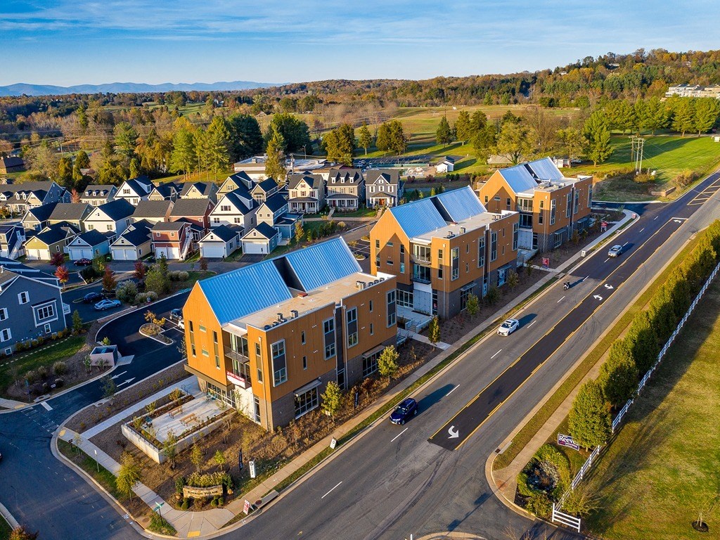 an aerial view of a group of houses with blue roofs