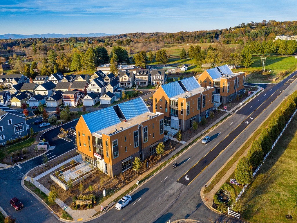 an aerial view of a group of houses with blue roofs