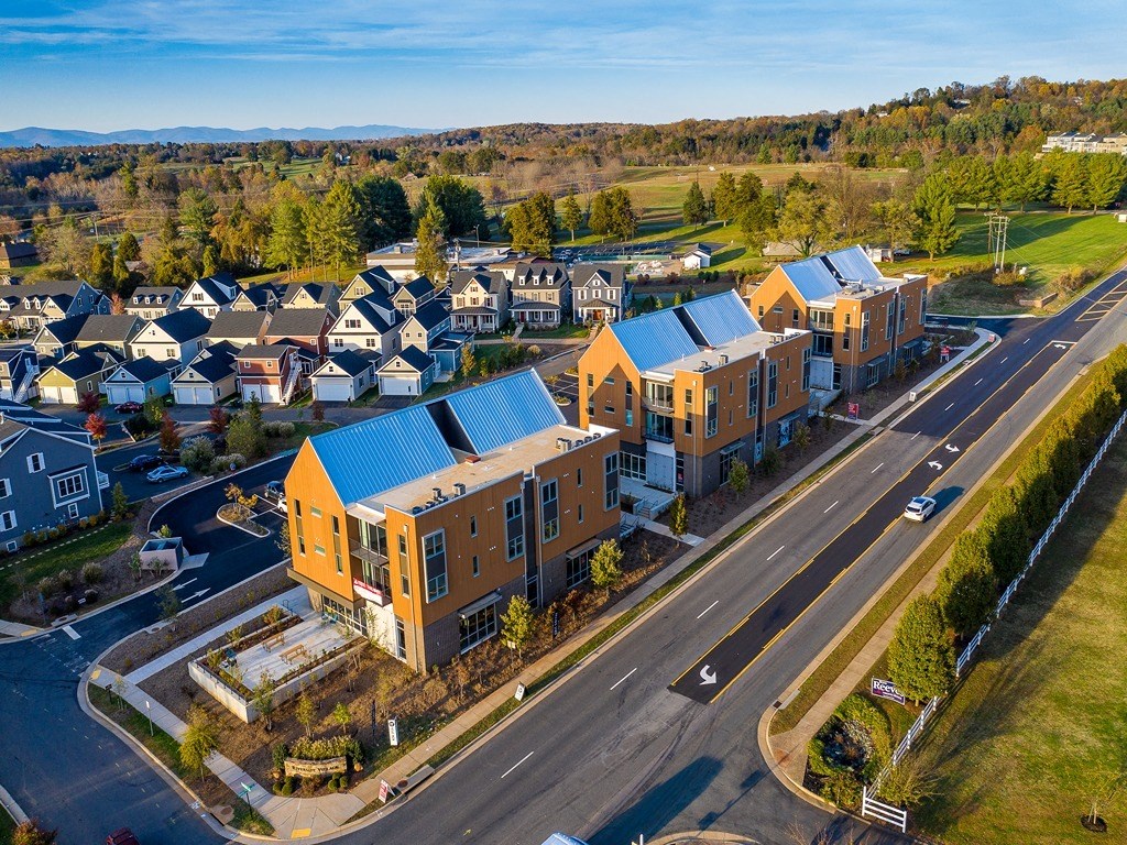 an aerial view of a group of houses with blue roofs
