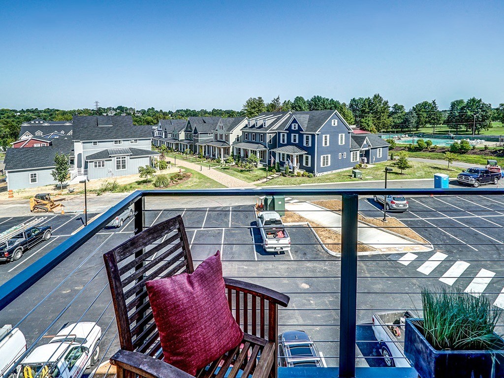 a chair sitting on a balcony overlooking a parking lot