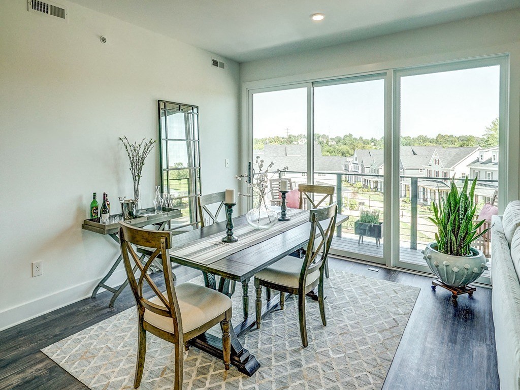 a dining room with a table and chairs and large windows