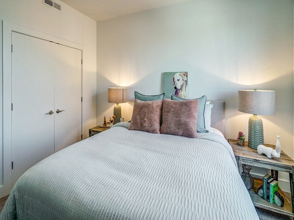 a bedroom with a bed and a painting of a dog