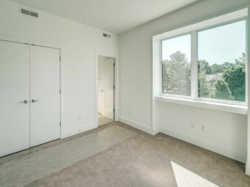 an empty room with white walls and a large window