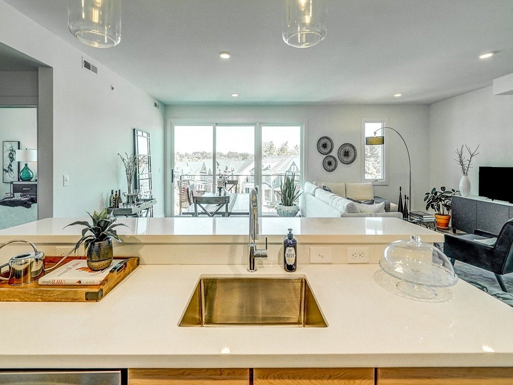a kitchen counter with a sink and a view of a living room