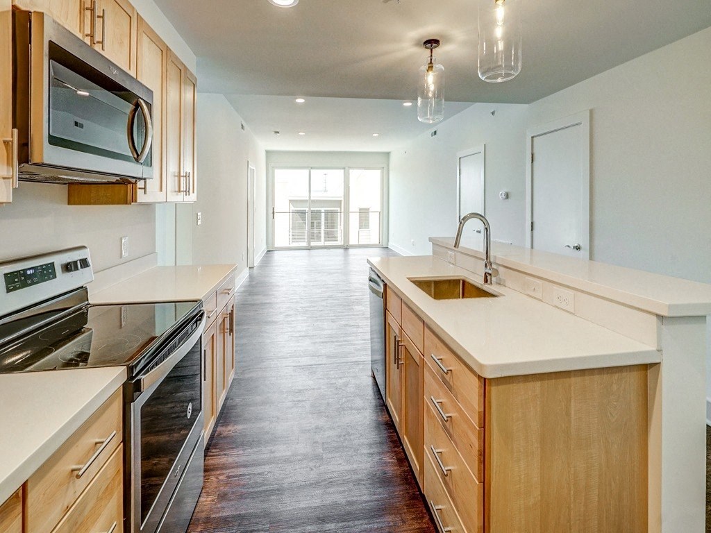 a large kitchen with wooden cabinets and white counter tops