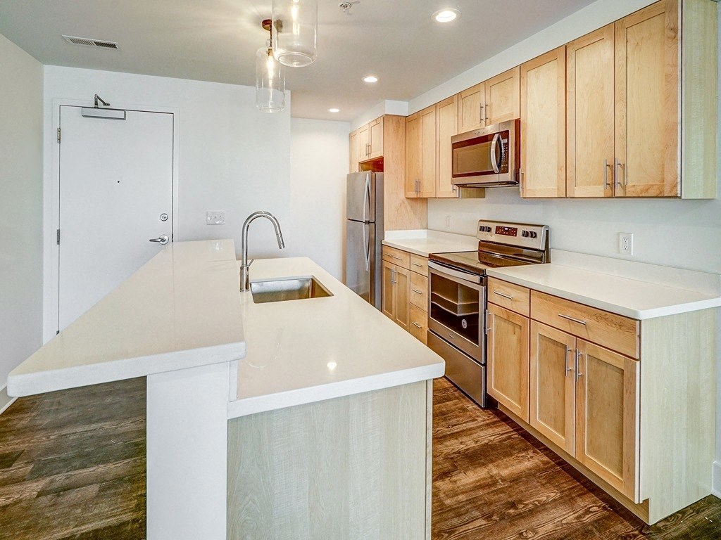 a kitchen with wooden cabinets and a white counter top