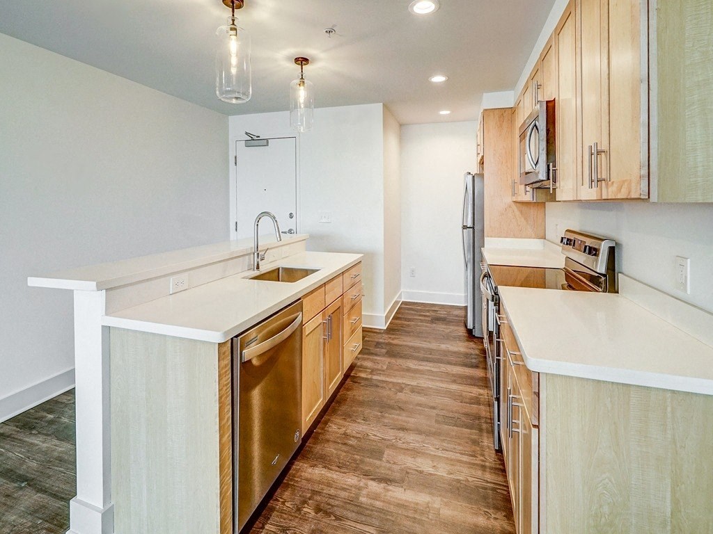 a kitchen with wooden cabinets and a white counter top