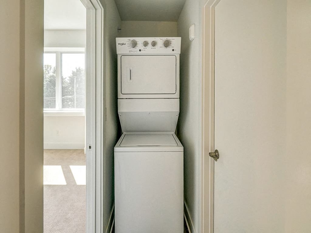 an empty laundry room with a washer and dryer in it