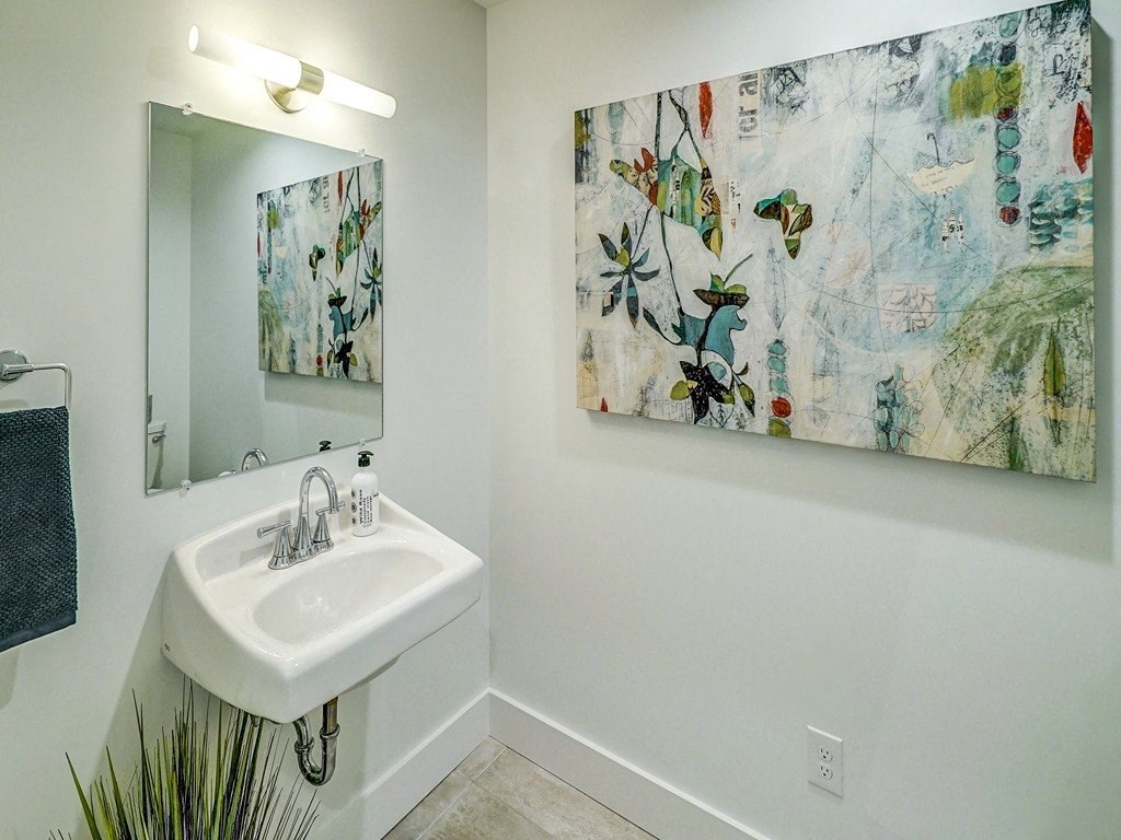 a bathroom with a sink and a mirror and a painting