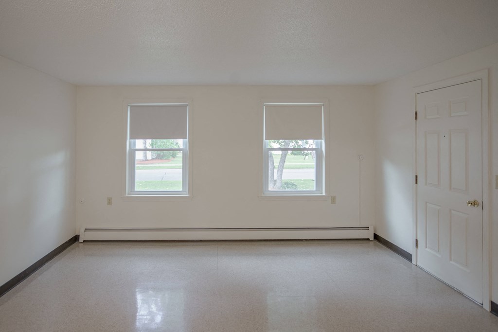 the living room of an empty house with two windows