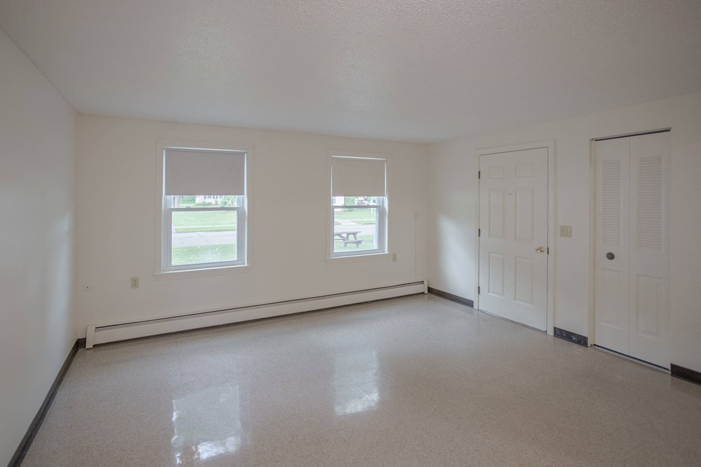 the living room of an empty house with white walls and a white door