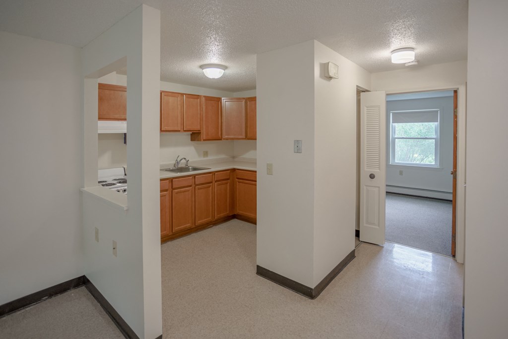the view of a kitchen and living room from the doorway of an empty house