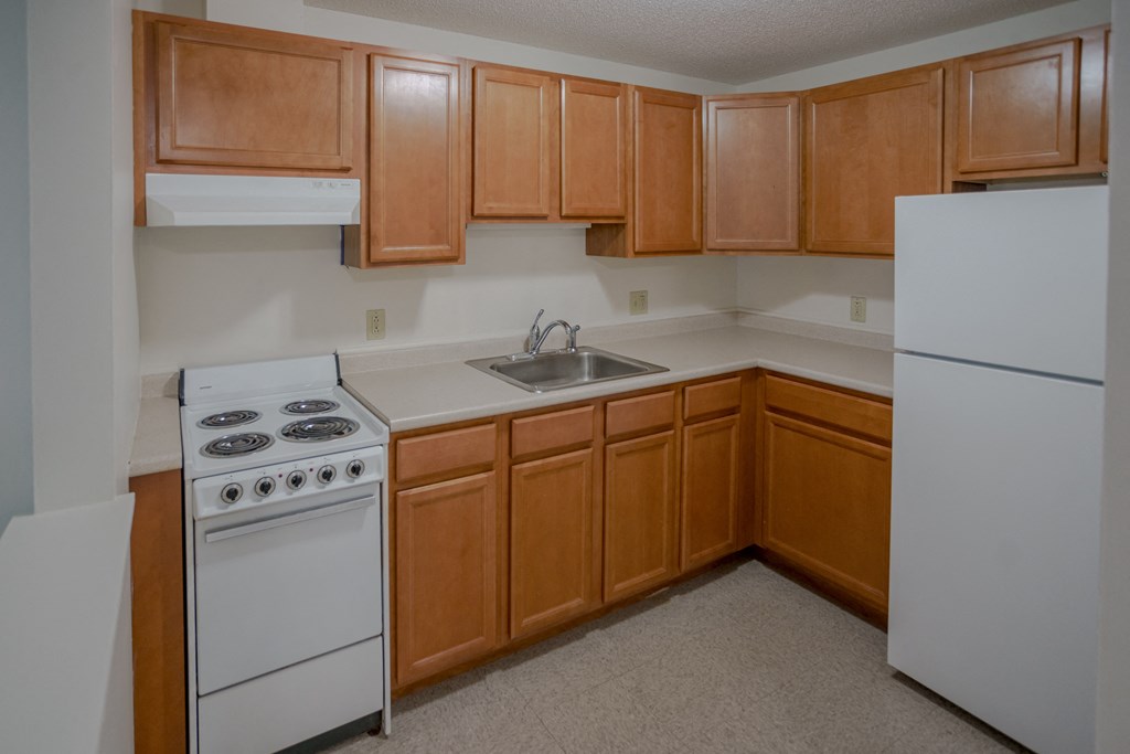 a kitchen with white appliances and wooden cabinets