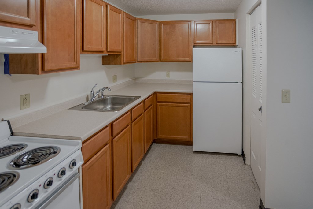 a kitchen with white appliances and wooden cabinets and a white refrigerator