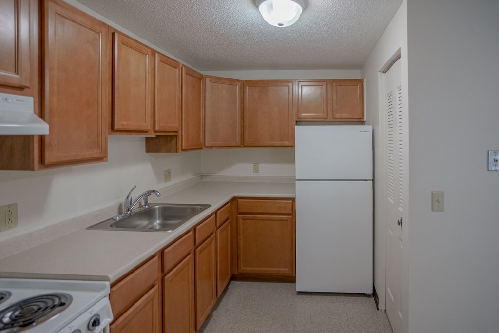 a kitchen with white appliances and wooden cabinets