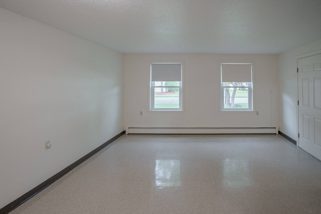 the living room of an empty house with two windows