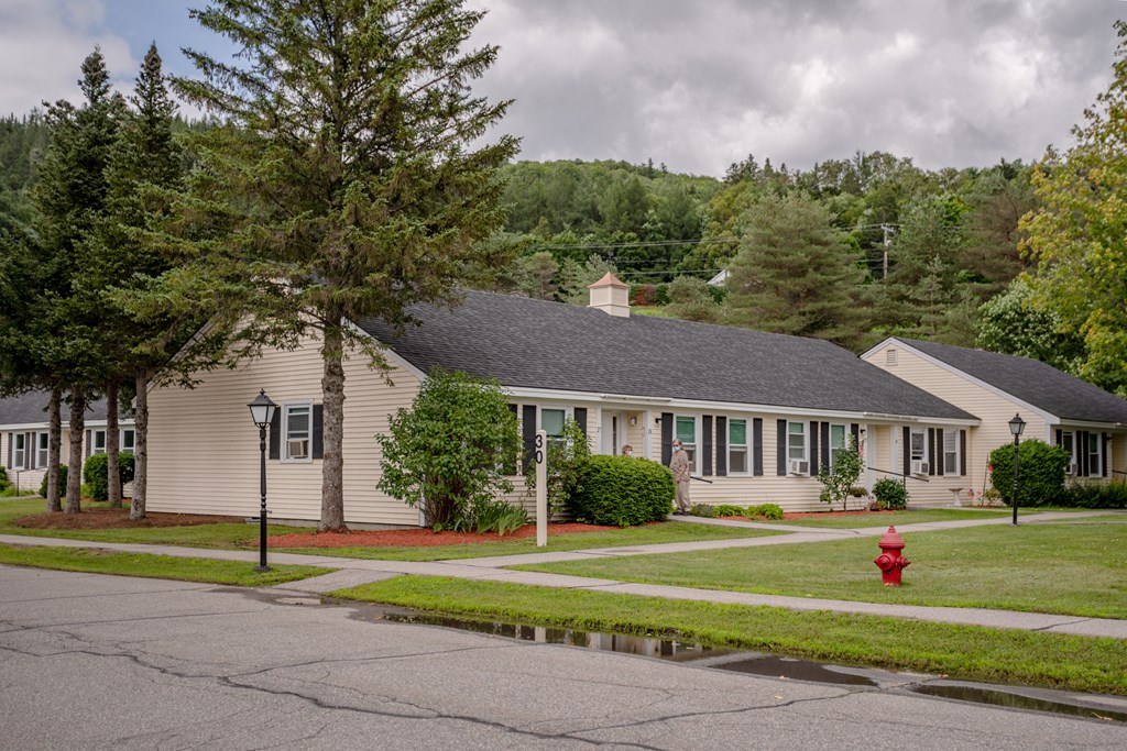 a white house with a red fire hydrant in front of it