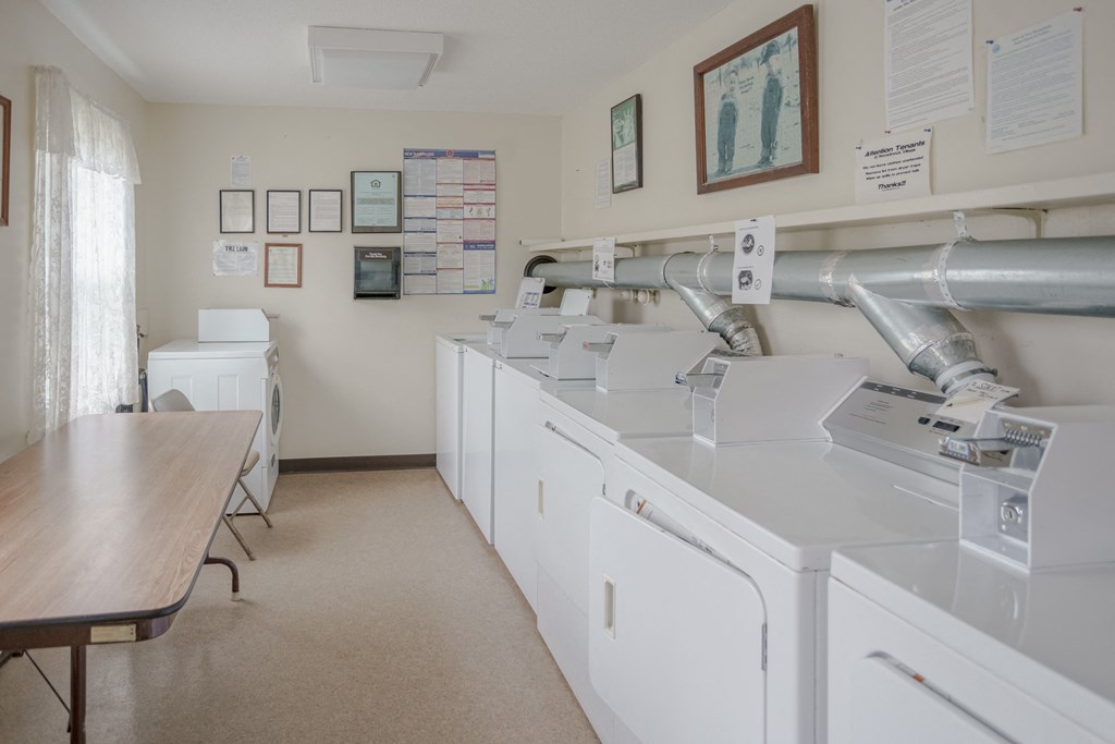 a laundry room with washing machines and a table