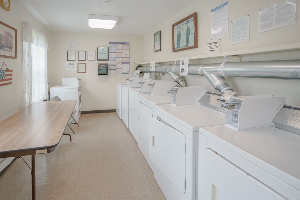a laundry room with washing machines and a table