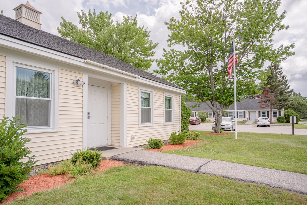 a small white house with an flag in front of it