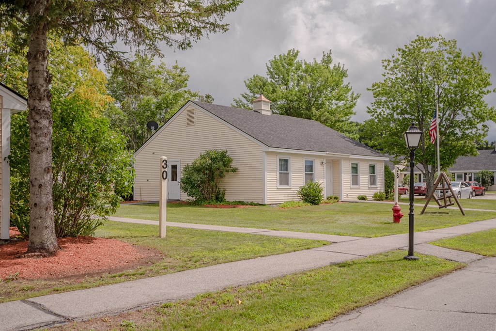 a white house with a red fire hydrant on a sidewalk
