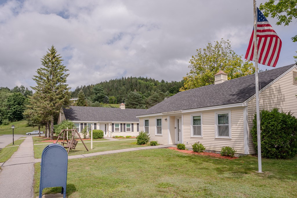 a white house with a mailbox and an flag in front of it