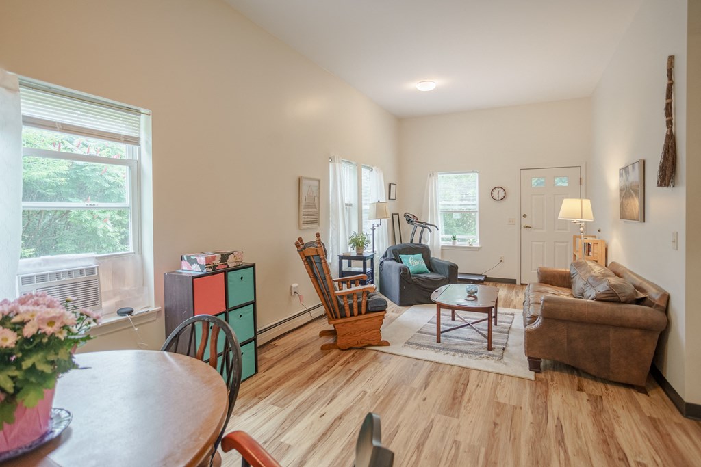 the living room and dining room of a house with a hardwood floor and furniture