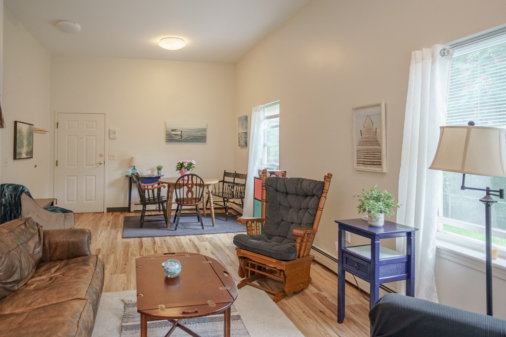 a living room with a couch and a chair and a dining room table