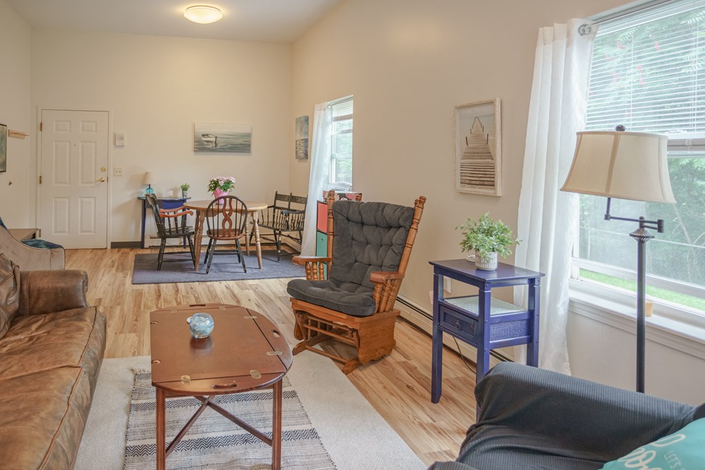 an open living room and dining room with a couch and a chair and a table