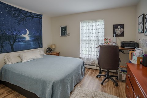 a bedroom with a bed and a desk with a chair