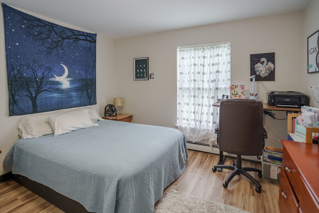 a bedroom with a bed and a desk with a chair