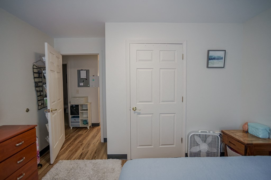 a bedroom with a bed and a closet and a door to a bathroom