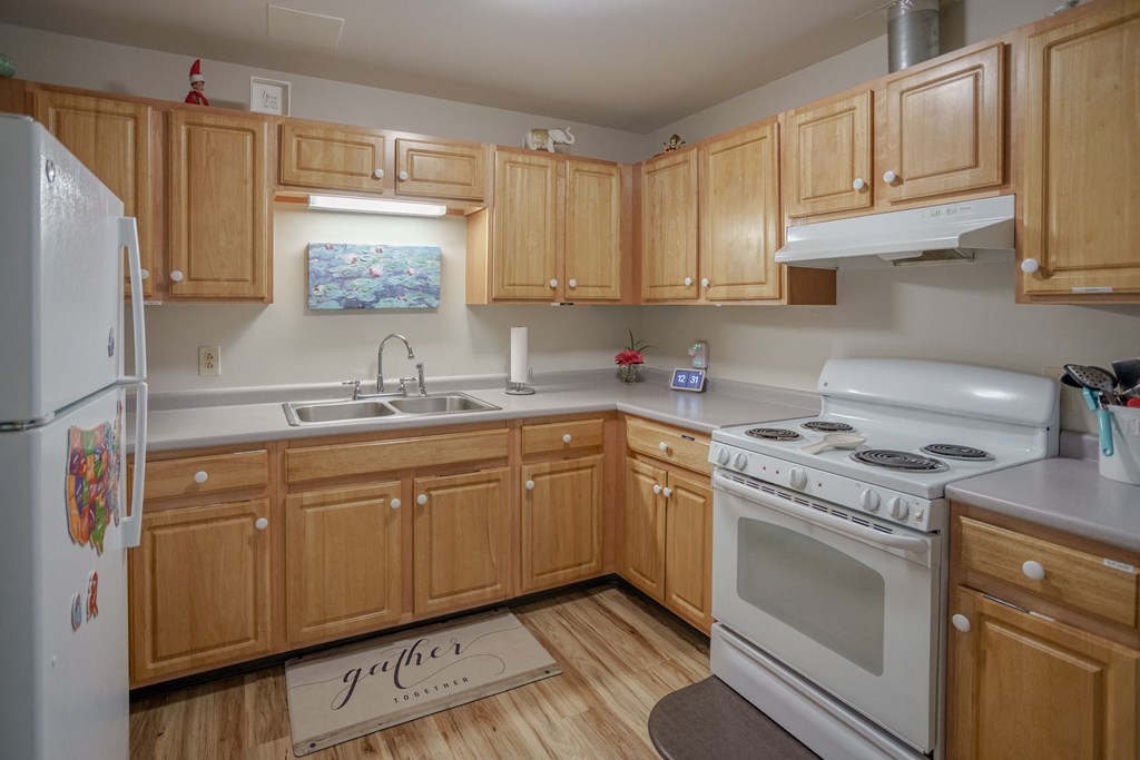 a kitchen with white appliances and wooden cabinets