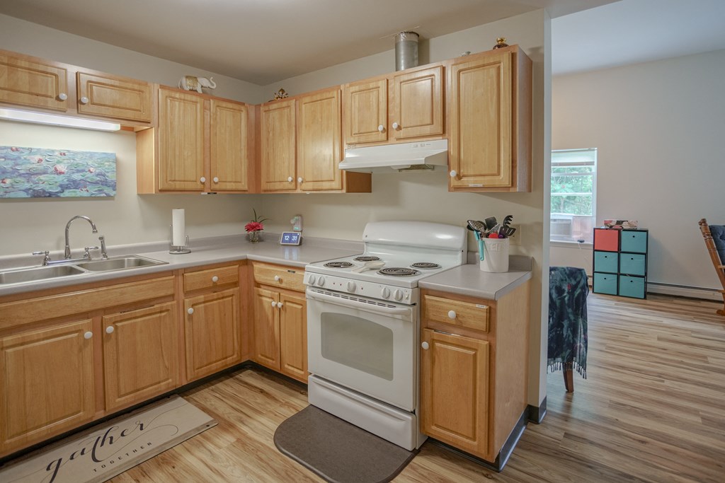 an empty kitchen with wooden cabinets and a white stove