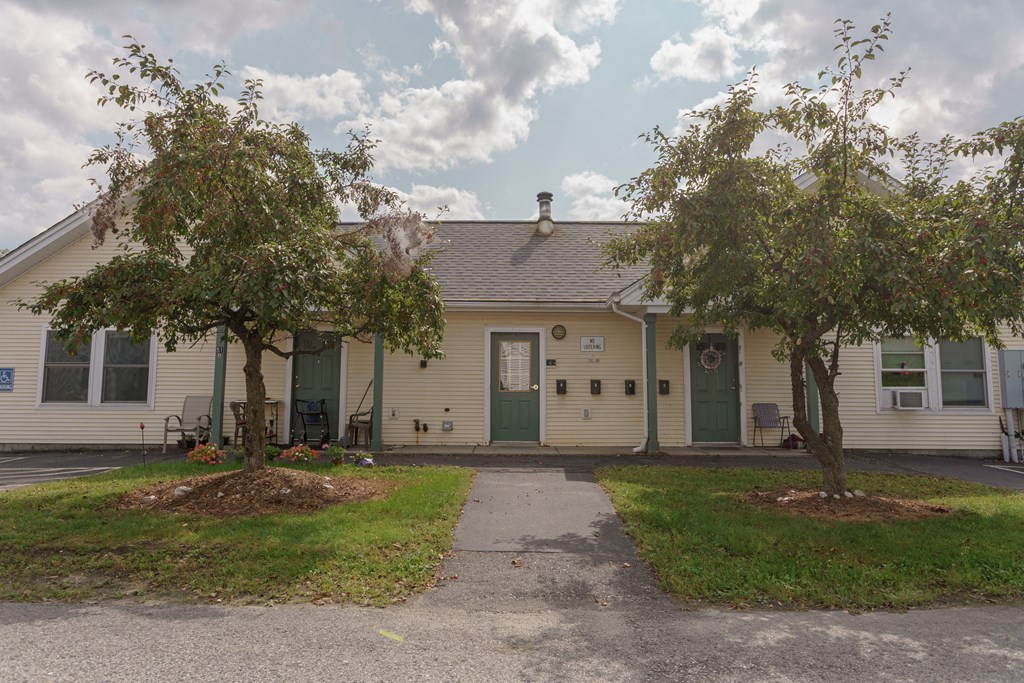 a white house with two trees in front of it