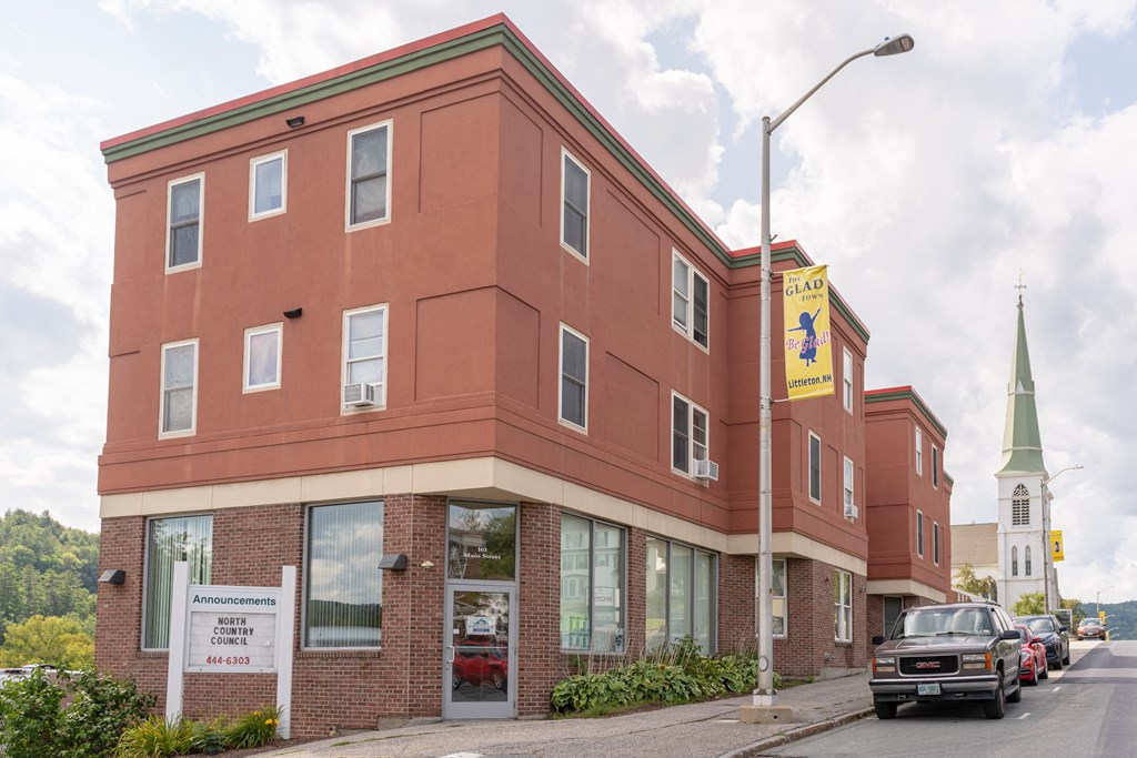 a large brick building with a church in the background