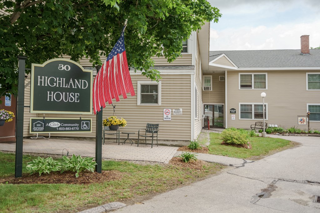 a sign for the highland house with an flag in front of it
