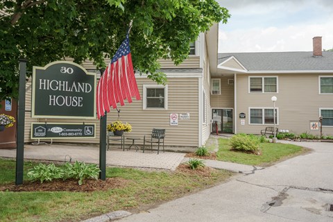 a sign for the highland house with an flag in front of it