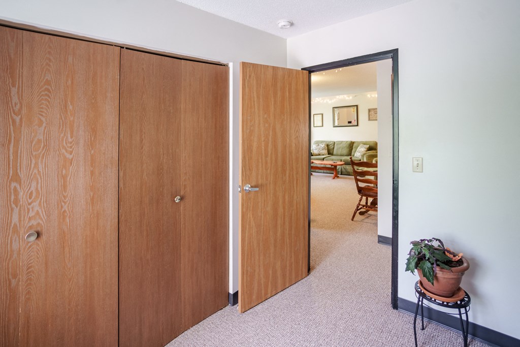 a bedroom with two doors and a living room with a couch