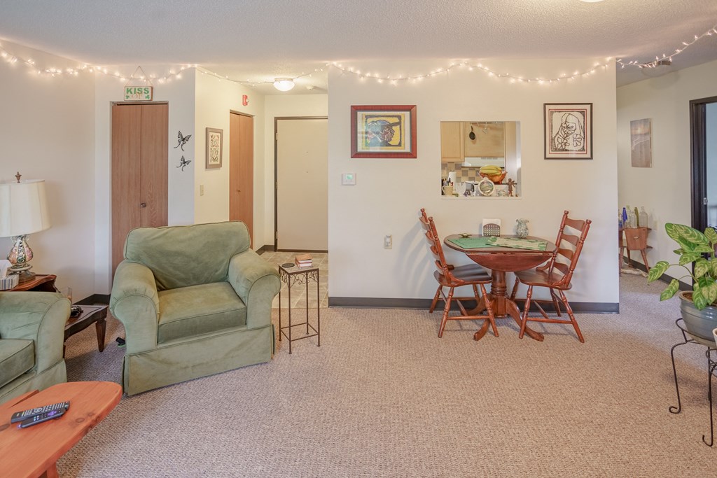 a living room and dining room with a table and chairs