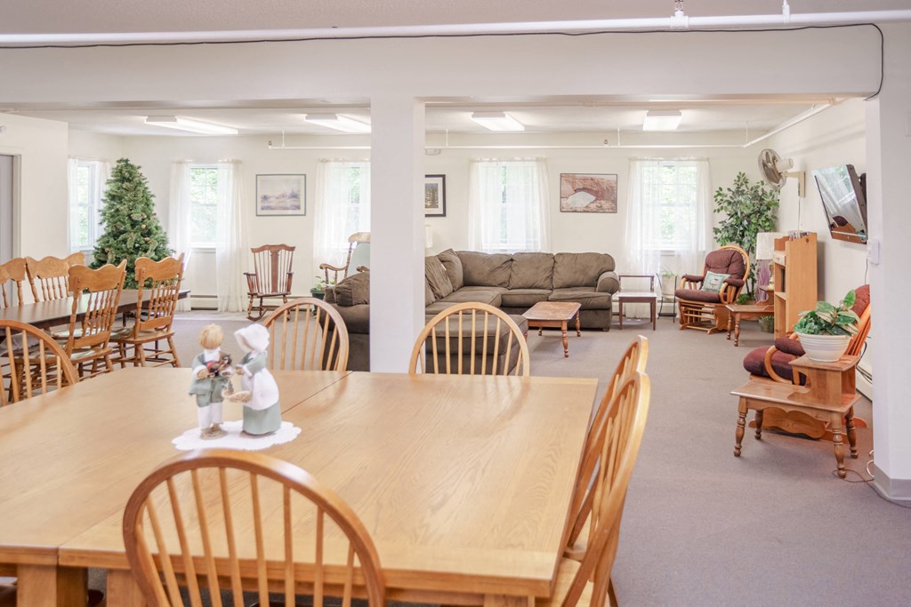a living room and dining room with a wooden table and chairs