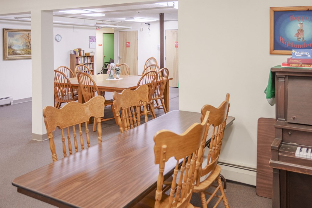 a dining room with a table and chairs and a piano