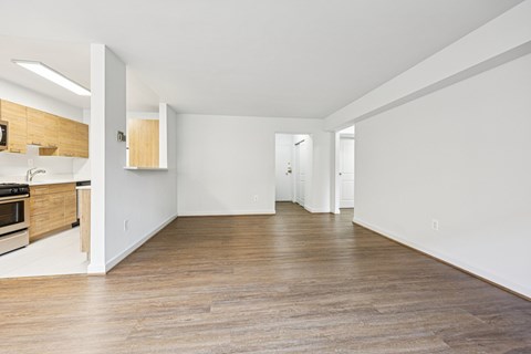 A spacious room with wooden flooring and white walls.