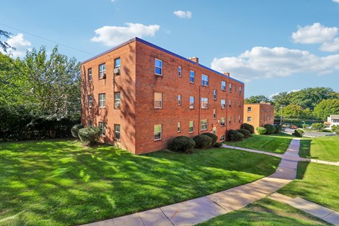 A red brick building with a green lawn in front.