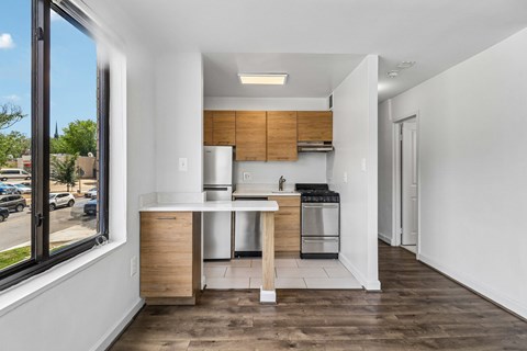 A modern kitchen with wooden cabinets and a white countertop.